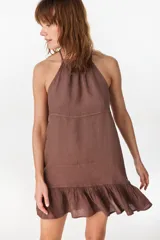 Vestido corto verde militar de lino, con escote halter fruncido en el cuello y detalle de volados en el ruedo.