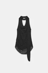 Top halter de viscosa con estampado de lunares, cuello halter, espalda descubierta y detalle de lazadas en el mismo tejido. Cuenta con bajo redondeado y cierre trasero con botones.
