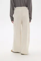 Pantalon de corte amplio y tiro alto, confeccionado en poliester, con bolsillos laterales tipo cargo.