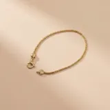 Pulsera de malla extensible confeccionada en oro 18k, con cierre de mosquetón.