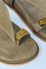 Sandalias de gamuza color tostado, con tira de dedo, hebilla ajustable en el talón y detalle metálico dorado.