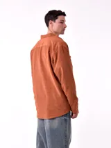 Sobrecamisa de hombre color azul marino, confeccionada en tejido de pana con textura acanalada. Presenta cuello camisero, cierre frontal con botones blancos y dos bolsillos de parche con solapa en el pecho.