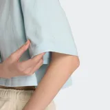 Remera celeste de corte cropped y mangas cortas, con logo de New Balance bordado en el pecho.