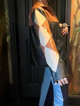 Campera de cuero sintético con cierre frontal, diseño de rombos en tonos marrón, beige y negro.