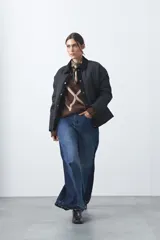 Campera tipo barn acolchada de color negro, con cuello de pana, cierre frontal con broches y bolsillos laterales. Presenta un diseño de silueta corta y relajada.