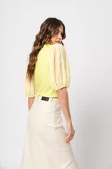 Blusa verde con cuello redondo y mangas cortas abullonadas.