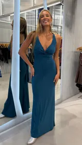 Vestido largo verde con brillo, escote en V cruzado y tirantes anchos.