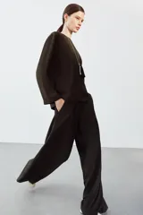 Pantalón de tiro alto con pierna ancha, confeccionado con detalle de pinzas en el delantero, bolsillos laterales y cierre frontal con cremallera y gancho metálico.