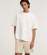 Bermuda masculina de corte slim, confeccionada en tejido de algodón con felpa. Presenta cintura elástica con cordón ajustable, bolsillos laterales y una pequeña etiqueta aplicada en el ruedo.