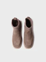 Bota corta de gamuza color verde militar, con caña de tejido elástico de punto en la parte superior, plataforma texturizada y tacón ancho.