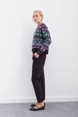 Pantalón blanco de tiro alto con elástico interno en la cintura, botones falsos y terminación con volado. Tiene bolsillos aplicados en delantero y falsos en espalda.