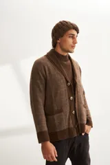 Cardigan marrón tejido con cuello smoking, cierre con botón y bolsillos delanteros.