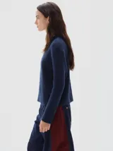 Polera de tejido de punto acanalado, con cuello subido y manga larga. Presenta un diseño al cuerpo con un pequeño bordado a tono en el frente.