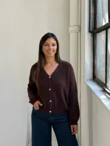 Saco tipo cardigan de punto color chocolate, con escote en V, cierre frontal de botones y mangas largas con puños acanalados.