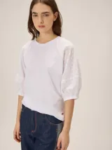 Remera blanca de algodón con cuello redondo y mangas raglán abullonadas confeccionadas en tejido broderie.