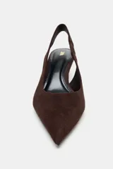 Zapato destalonado de ante color marrón, con tacón kitten fino y punta afilada. Cuenta con una tira trasera elástica para mayor ajuste.