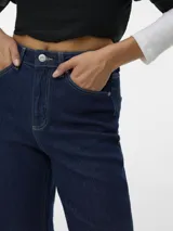 Jean de corte wide leg y tiro alto, confeccionado en denim azul oscuro. Presenta un diseño de cinco bolsillos y un ruedo ancho con doblez marcado.