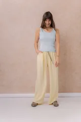Pantalón amarillo de corte amplio y pierna recta, confeccionado en tela liviana con caída fluida. Cuenta con cintura elastizada, cordón regulable en contraste y bolsillos laterales.
