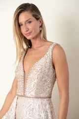 Vestido largo de tul color champagne, bordado en hilo de seda y canutillos al tono, con escote en V y sobrefalda.