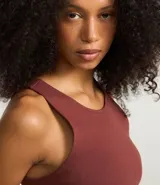 Top cropped sin mangas, color marrón oscuro, de corte ajustado al cuerpo y cuello redondo. Presenta textura acanalada.