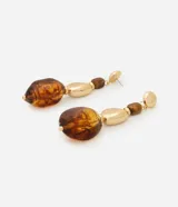 Aros colgantes de diseño maxi, compuestos por una base de media esfera con baño dorado y colgantes de resina en tono ámbar con detalles metálicos dorados.