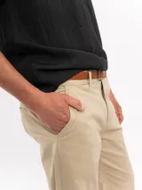 Pantalón chino de corte regular y tiro medio, color azul marino, con cierre de botón y cremallera, bolsillos laterales y traseros, y terminación recta.