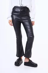 Pantalón tipo oxford de cuero sintético con acabado brillante y costuras verticales frontales. Presenta un corte ajustado en la parte superior que se ensancha ligeramente hacia el ruedo.