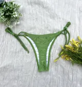 Conjunto de bikini verde con corpiño triangular y bombacha colaless con tiras para atar en los costados.