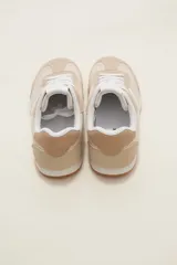 Zapatillas de estilo urbano color marrón con detalles en blanco, confeccionadas en material textil y sintético, con cordones blancos y suela de goma.