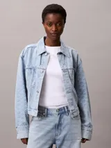 Campera de jean estilo cropped con lavado claro, cuello en punta, cierre frontal con botones metálicos y doble bolsillo en el pecho. Presenta un diseño clásico con costuras reforzadas y parche con logo de la marca.