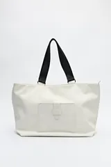 Bolso blanco de símil cuero con terminación suave. Tiene asas anchas de cinta negra y un bolsillo frontal con solapa.