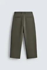 Pantalón de corte relajado en color verde militar, con diseño de pliegues frontales, bolsillos laterales y cierre de cremallera con botón.
