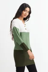 Sweater de tejido de punto con franjas horizontales en color blanco, verde claro y verde oscuro. Tiene cuello en V con botones.