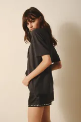 Remera de algodón color gris oscuro con un gran rayo estampado con lentejuelas negras al frente.