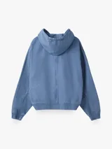 Chaqueta con capucha color celeste de lona pesada, con cierre frontal y bolsillo con cierre en el pecho.