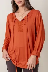 Remera negra de algodón de manga larga con aplique de encaje en el escote.