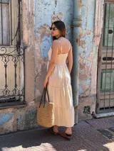 Vestido largo color beige, con tirantes finos, escote en V y detalles de inserciones de encaje broderie en la cintura y los volados de la falda.