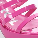 Sandalias de plataforma color blanco charol, con tres tiras horizontales en el empeine, pulsera al tobillo con hebilla y taco cuadrado.