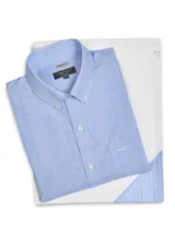 Camisa de manga larga de corte regular fit, color celeste con diseño a cuadros sutiles blancos. Cuenta con cuello abotonado, cierre frontal de botones, bolsillo ojal en el pecho con el logo bordado y un acabado resistente a las arrugas.