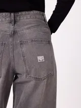 Jean de corte wide leg con diseño de pata ancha y costuras laterales visibles. Presenta un lavado azul clásico con efecto desgastado y cierre frontal con botón y cremallera.