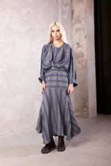 Falda midi de lino con diseño de rayas verticales en tonos gris, azul y naranja. Presenta un corte con caderín ajustado y una falda amplia con cortes dinámicos que aportan movimiento y volumen.
