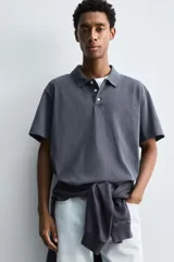 Polo de manga corta con cuello solapa y cierre frontal de tres botones. Presenta un diseño de corte relajado con acabado de efecto lavado.