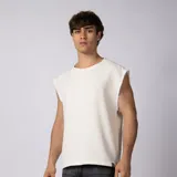 Musculosa oversize de lino color blanco, de corte suelto, cuello redondo, sin mangas con terminaciones deshilachadas y textura marcada.