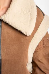 Chaleco estilo gamulán de color negro, con interior y cuello de corderito sintético. Presenta cierre frontal, detalles en cuero sintético y corte oversize.