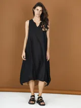 Vestido midi negro de popelina con corte globo y detalle de flor en el hombro.