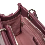 Cartera estructurada compacta de material símil cuero color bordó, con solapa frontal que tiene un botón imantado y el logo "XL" grabado. Posee doble manija fija y correa larga regulable y desmontable. Los herrajes son metálicos color plateado.