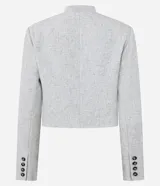 Chaqueta de sastre estructurada color gris claro, con cuello redondo tipo rectilínea, cierre frontal con botones y mangas largas con botones en los puños. Presenta un corte levemente corto y diseño minimalista.