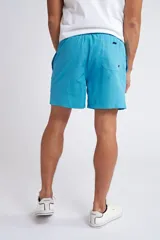 Short de baño color turquesa con cintura elástica y cordón ajustable. Presenta bolsillos laterales y un bolsillo trasero, con el logo de la marca bordado en la parte inferior de la pierna.