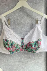 Soutien reductor con aro, confeccionado en lycra estampada con flores y puntilla negra. Breteles regulables.