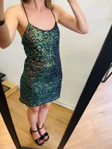 Vestido corto de lentejuelas tornasoladas con espalda baja y tirantes finos cruzados.